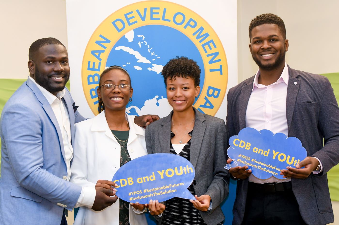 Four smiling young people holding youth-focused social media props