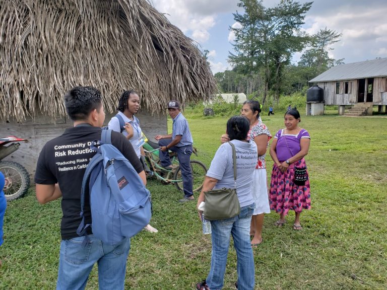 group of persons outside a village in Belize