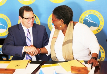 CDB President Smith (l.) and Prime Minister of Barbados Mottley shaking hands after signing the loan