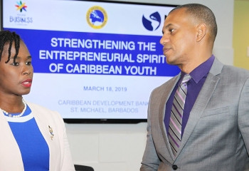 CDB Director of Project Daniel Best (at right in grey suit), in conversation with Executive Director of the Barbados Youth Business Trust Cardell Fergusson (in blue dress with of white jacket)