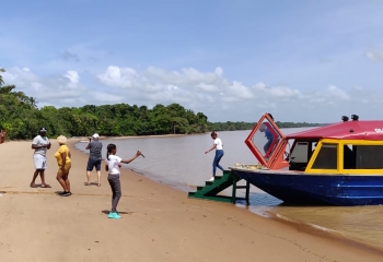 People disembarking onto a beach from a boat tour