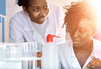 women in lab coats testing items