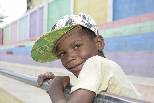 young boy with cap on looking into the camera