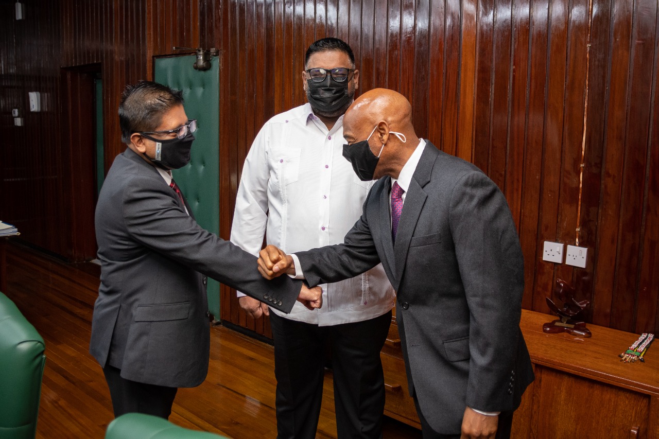 Dr Leon greets Dr Singh with Dr Ali looking on