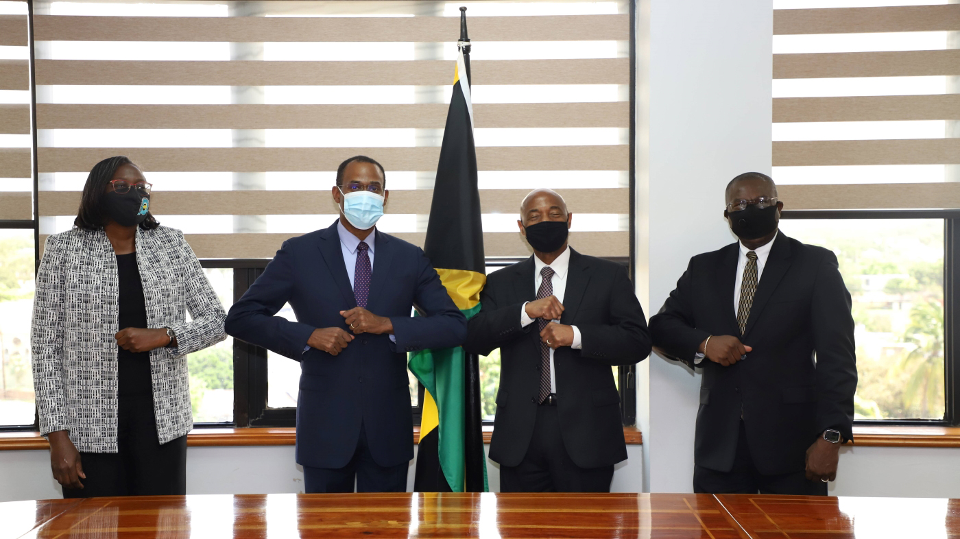 F.l.t.r. Jamaican Financial Secretary Darlene Morrison, wearing a white a grey blazer, Jamaican Finance Minister Dr Nigel Clarke, CDB President Dr Gene Leon, CDB Vice-President Isaac Solomon, all wearing dark suits