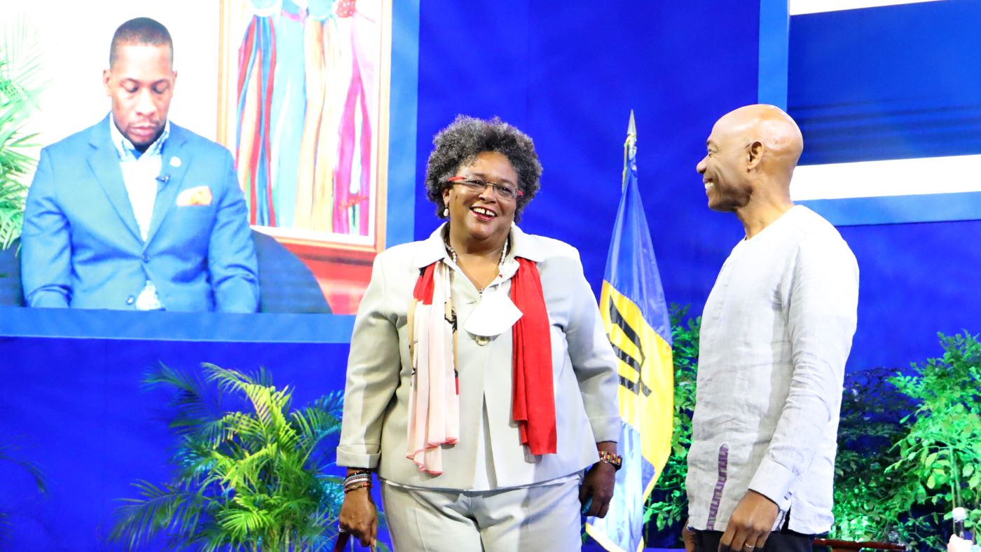 Prime Minister Mia Mottley in conversation with CDB  President Dr Gene Leon with ECCB Governor Timothy Antoine in background on large screen