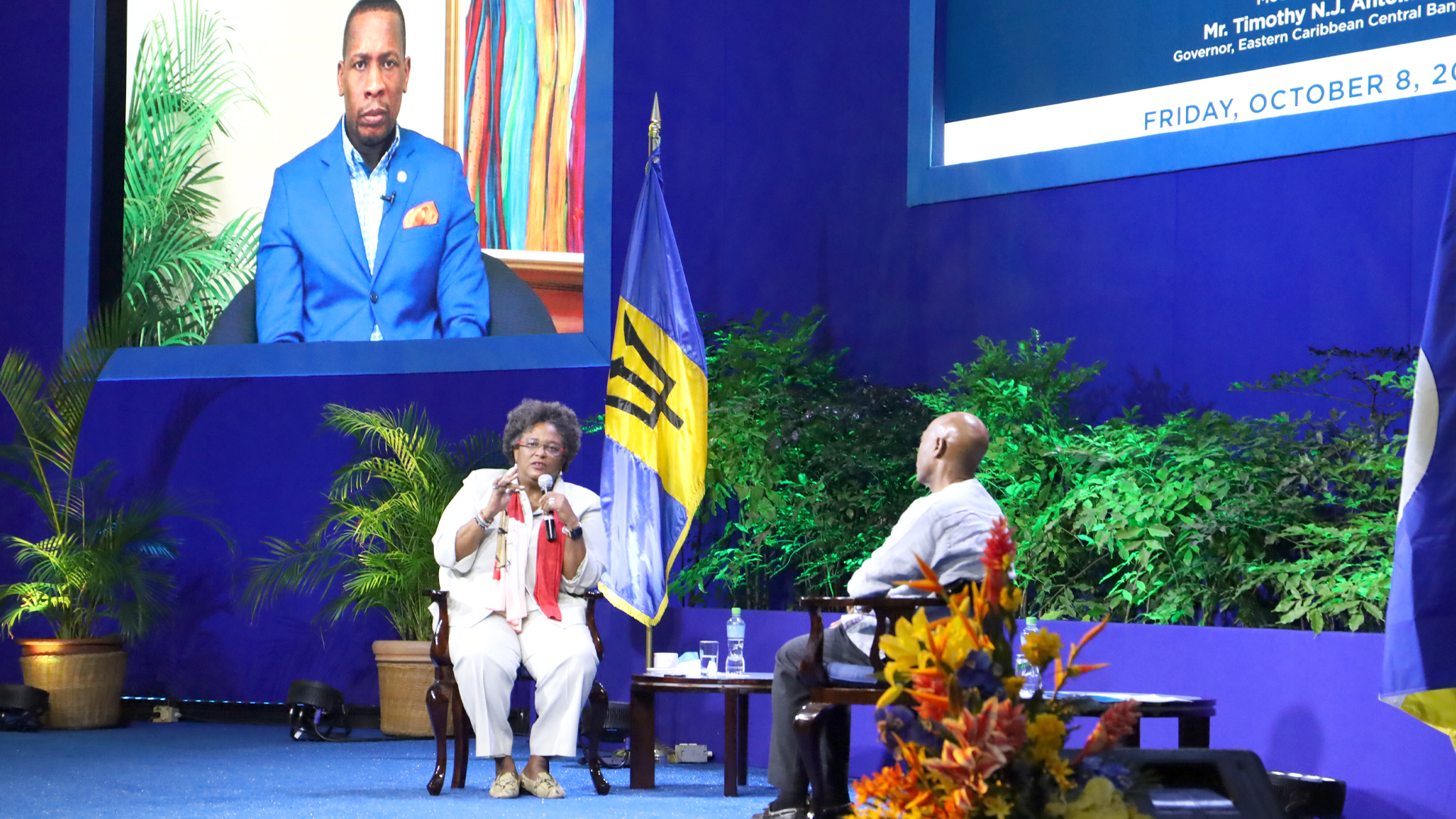 2-Prime Minister Mia Mottley in conversation with CDB  President Dr Gene Leon with ECCB Governor Timothy Antoine in background on large screen