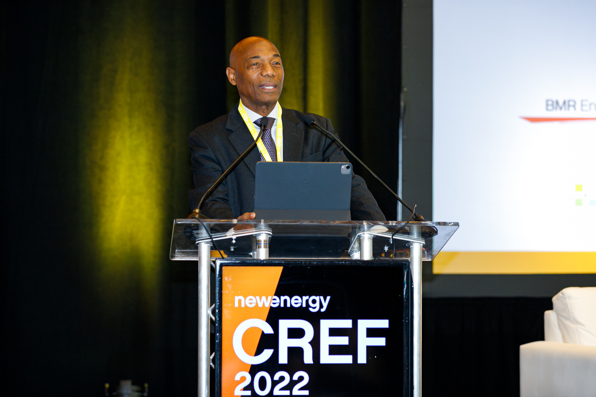 Dr. Leon wearing a dark suit standing lectern with CREF branding