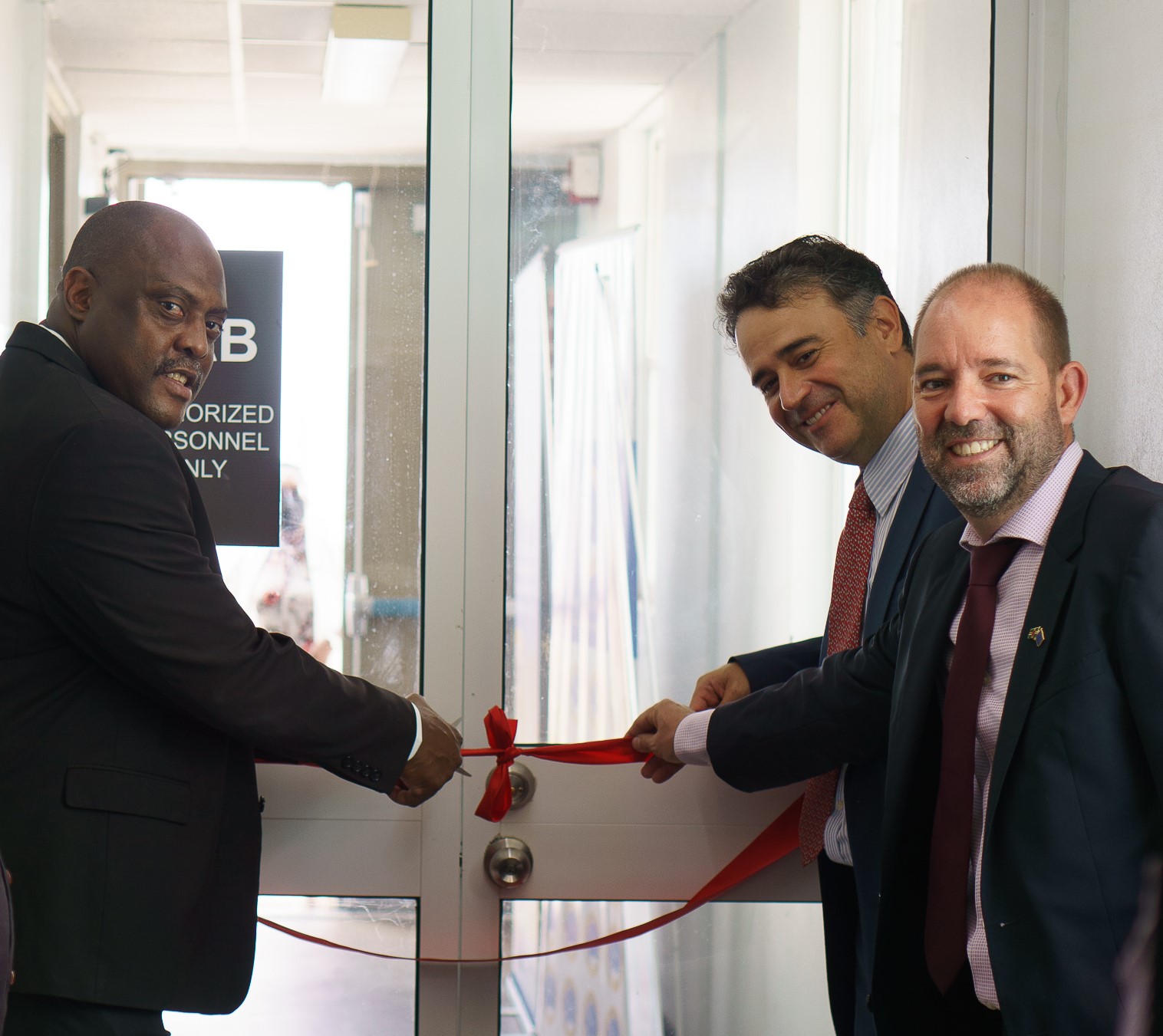 Dominica's Minister for Trade, Commerce, Innovation, Entrepreneurship and Business Development, the Honourable Ian Douglas; Head of CDB’s Private Sector Unit, Mr. Miguel Almeyda; and  Mr. David Mogollon, Head of Cooperation for the EU Delegation to Barbados, the Eastern Caribbean States, the OECS, and CARICOM/CARIFORUM cut the ribbon during the ceremony to commission lab upgrades at the Dominica Bureau of Standards