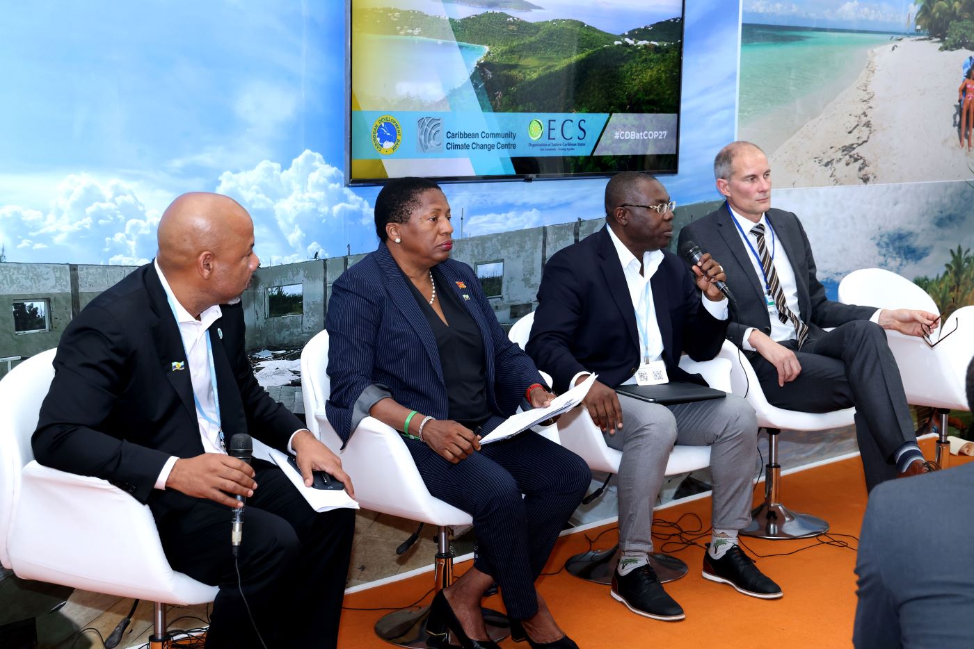 Four panelists seated on stage in front of audience