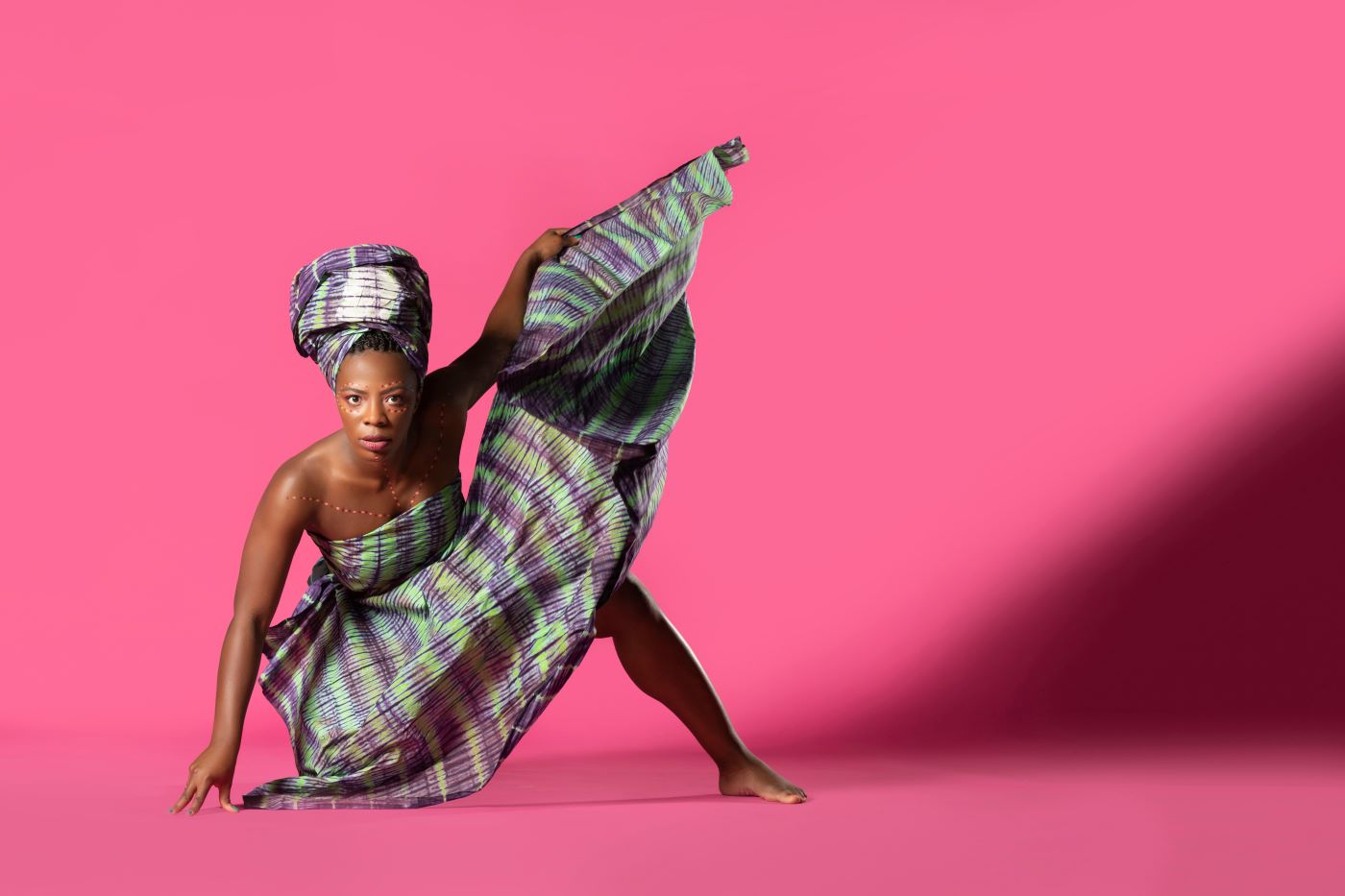 dancer posing against pink background