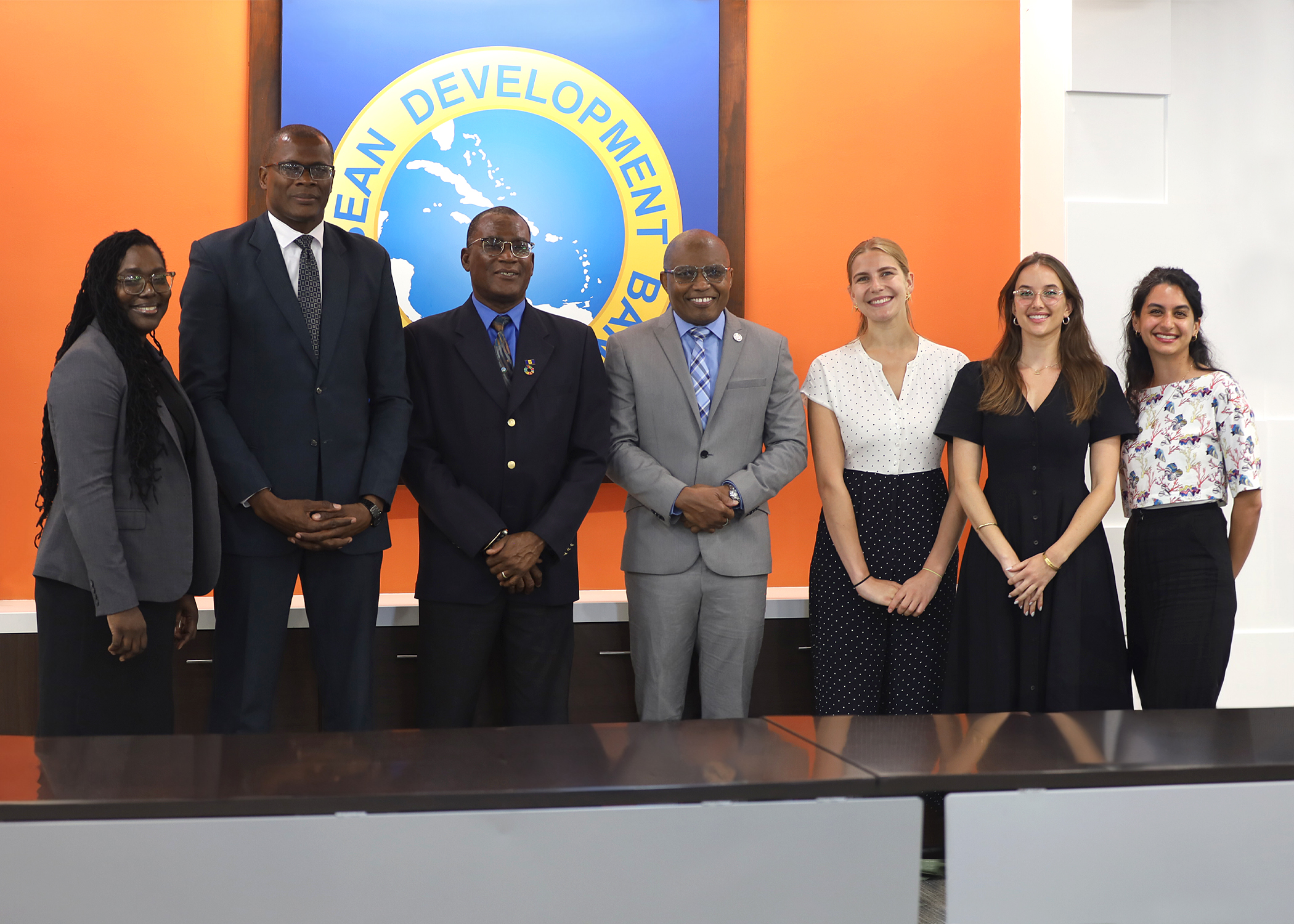 seven persons standing in a row in business attire