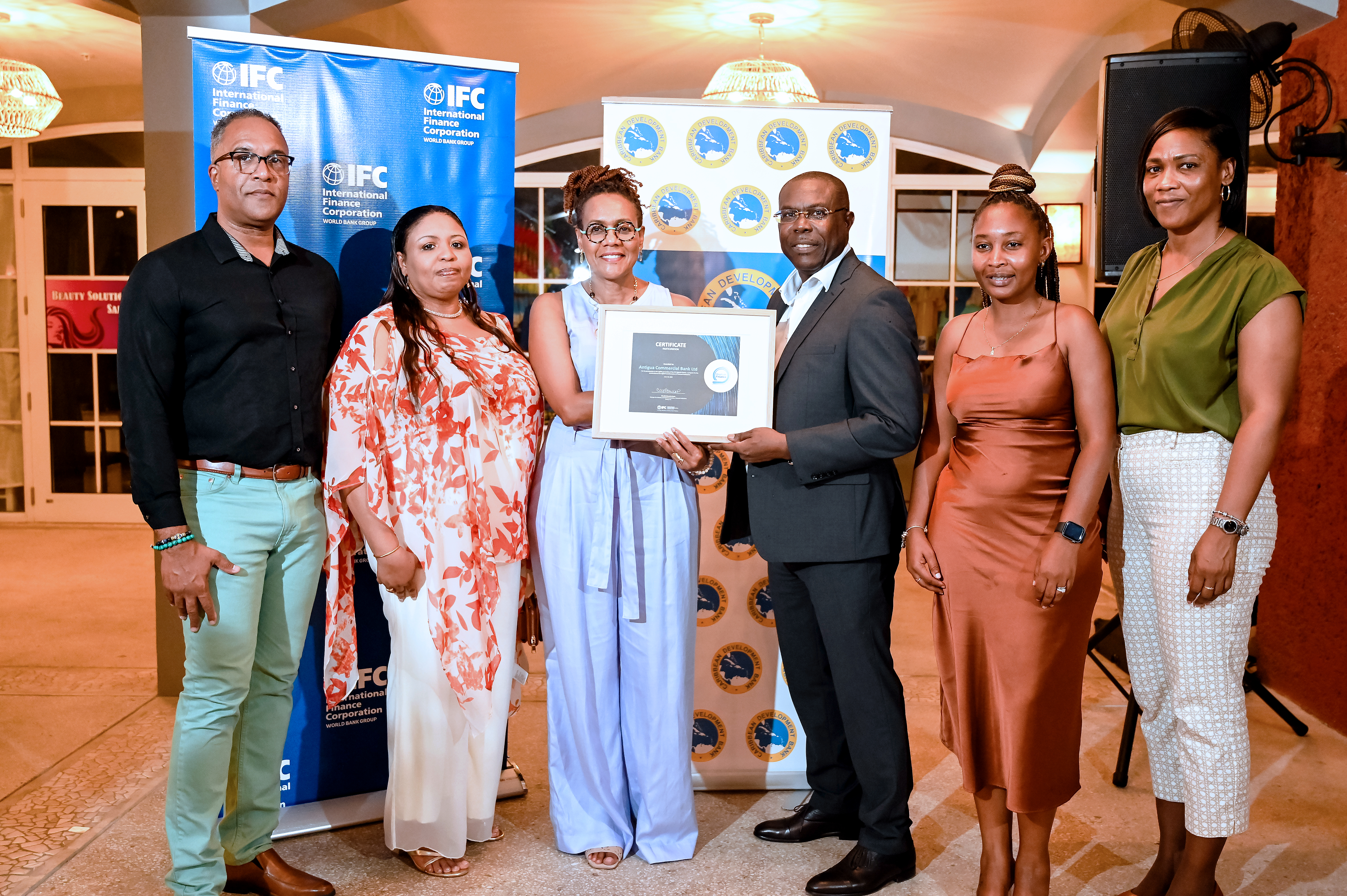 Group of business persons standing with two persons holding a certificate