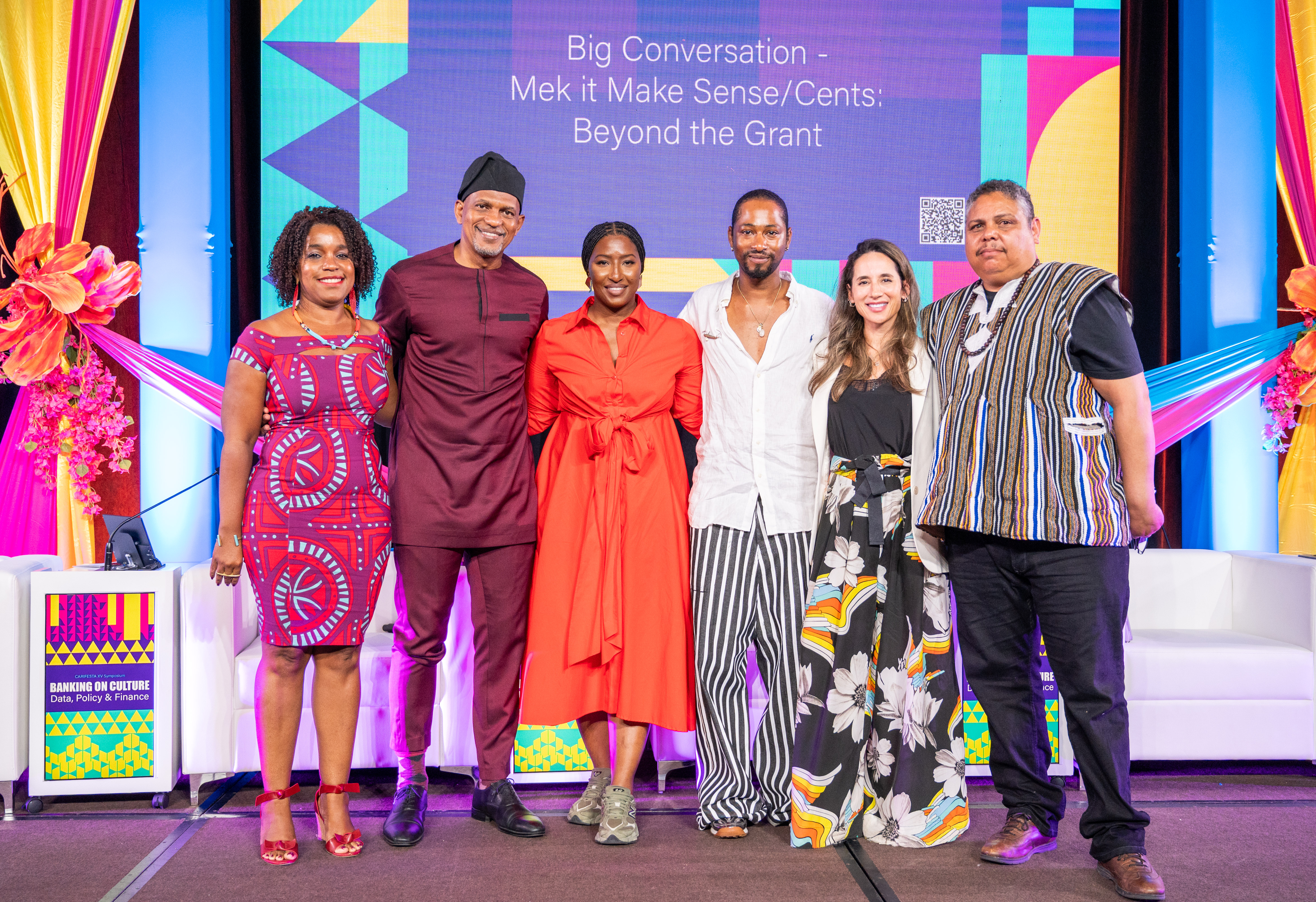 group of three women and three men dressed in colourful attire standing together on stage