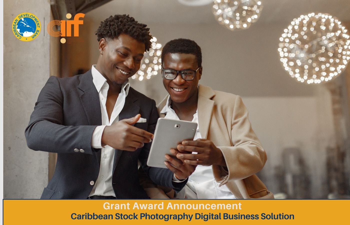 two black men one holding a tablet smiling dressed professionally