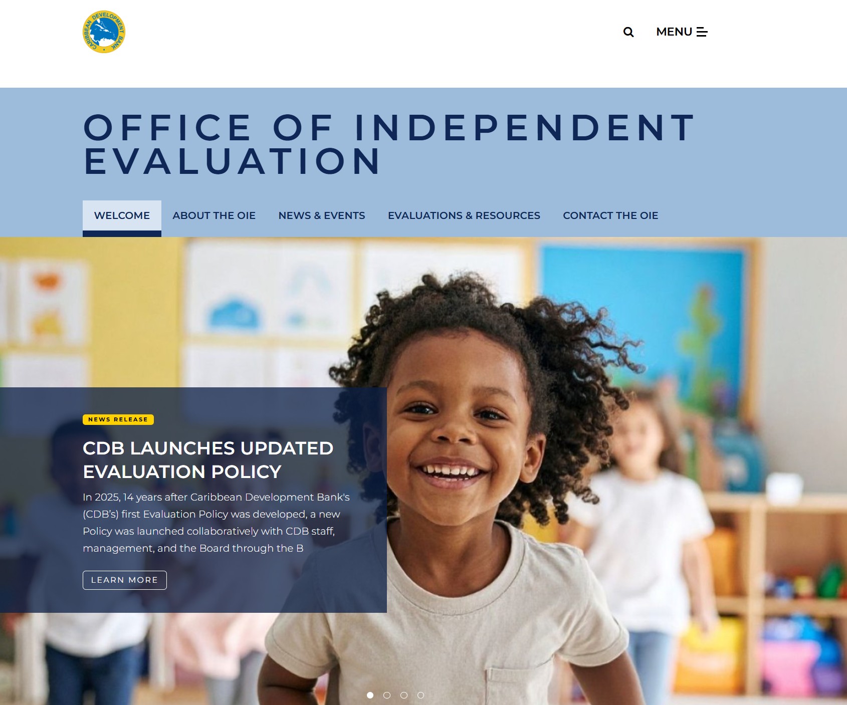 Website homepage for the Office of Independent Evaluation showing navigation tabs and a banner announcing the Caribbean Development Bank’s updated evaluation policy, with an image of a child in a classroom.