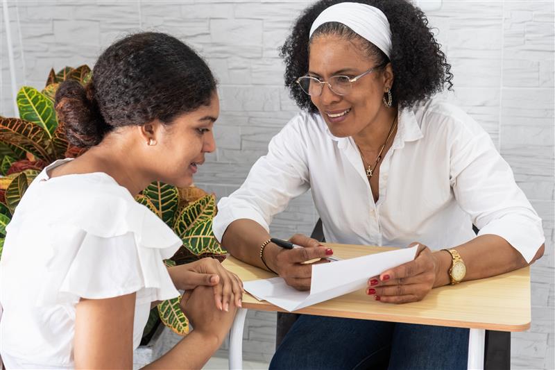 Older woman speaking to a younger woman about a document
