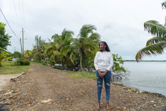 Black woman standing on a dirt road in a rural community