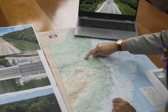 A woman's finger points to an area on a map.