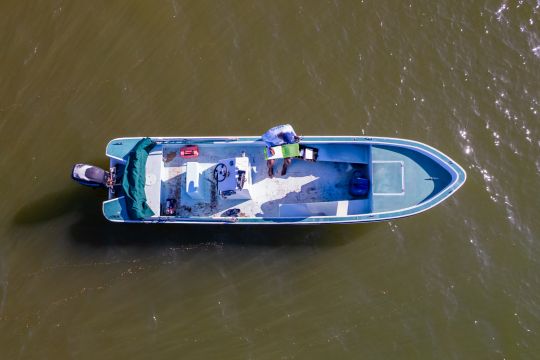 A small boat floats in a lagoon.
