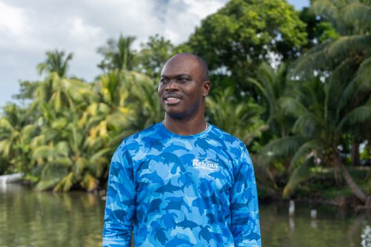 Young black man standing on the edge of a lagoon