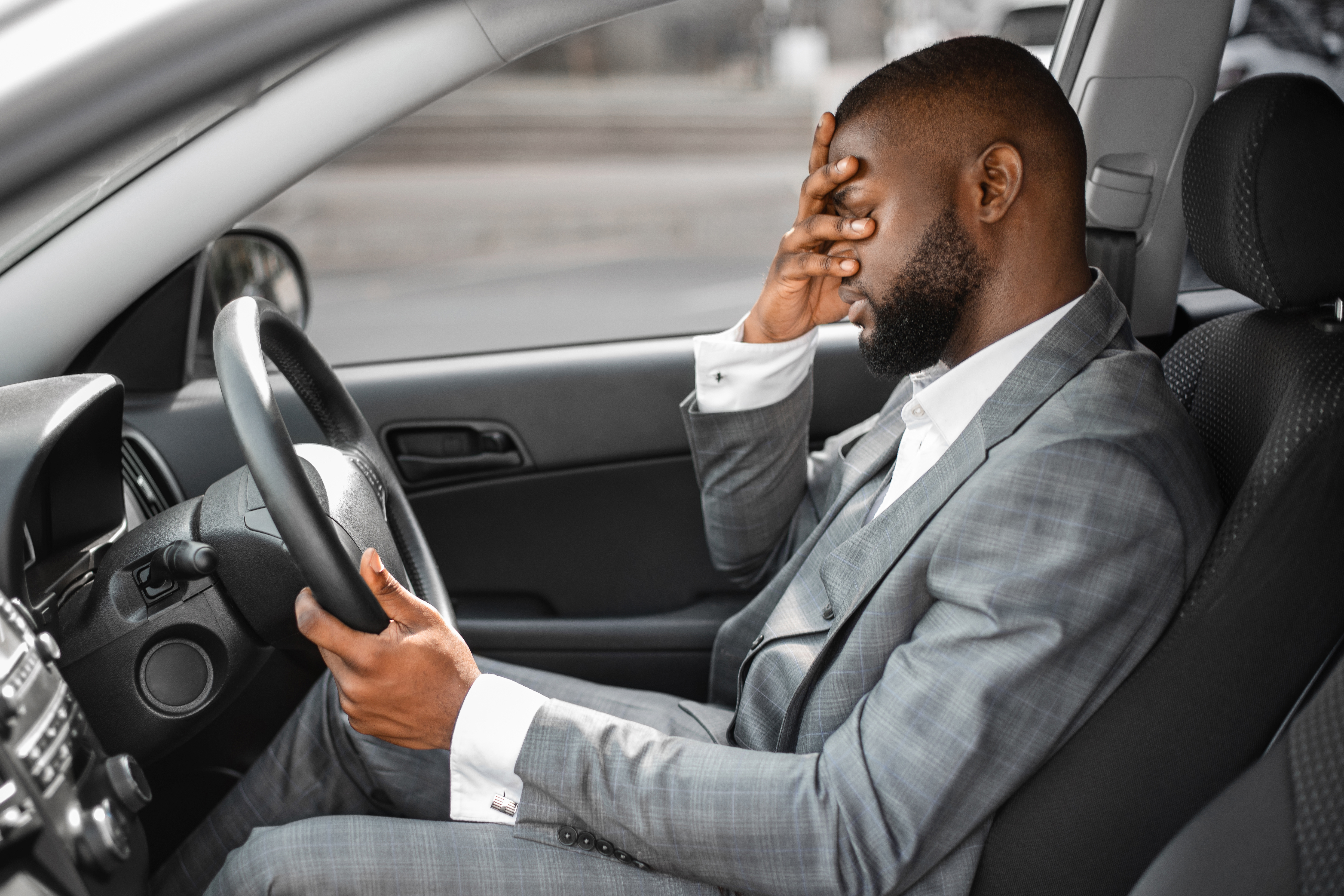 Man frustrated sitting in car in traffic 