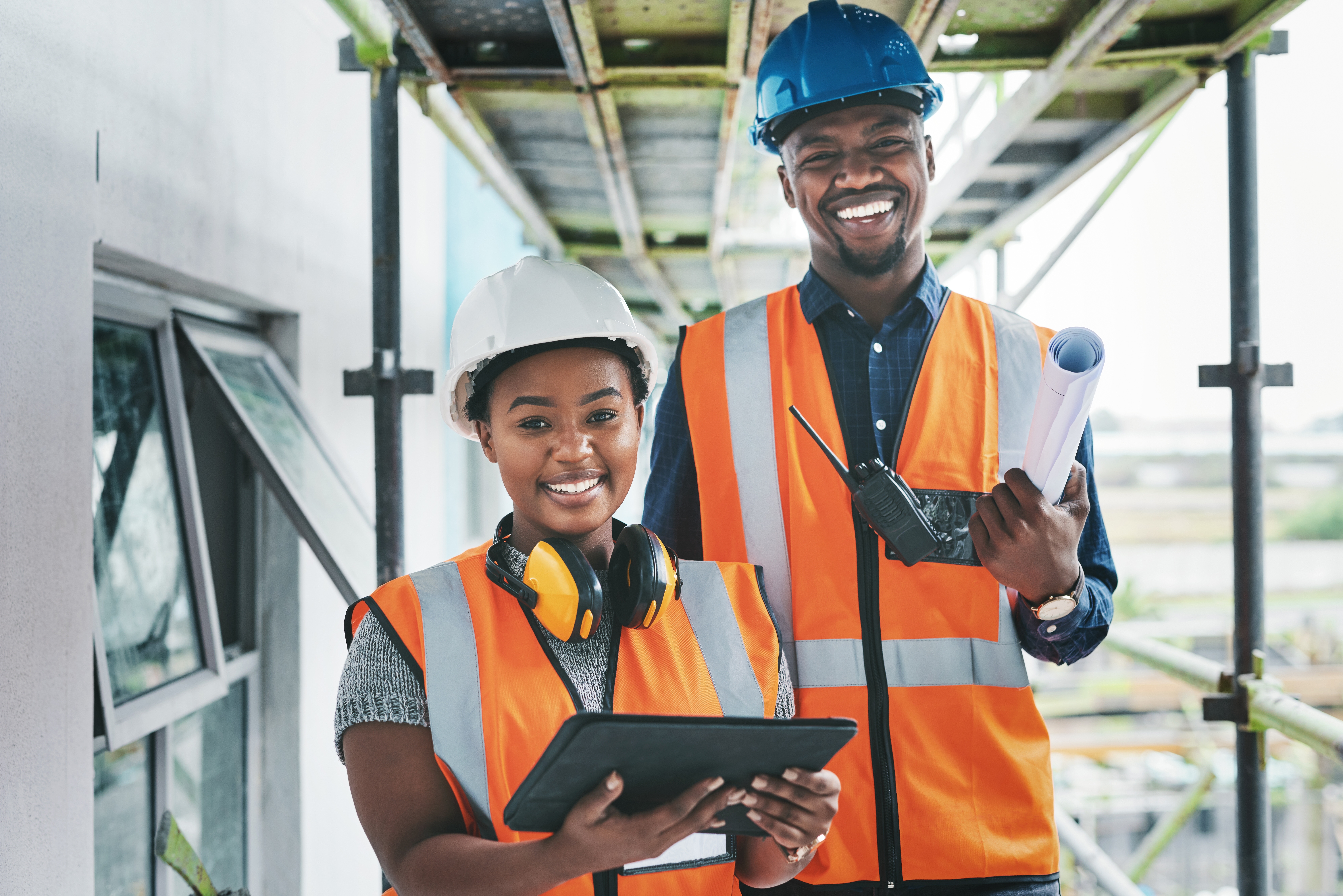 Female and male construction workers smiling 