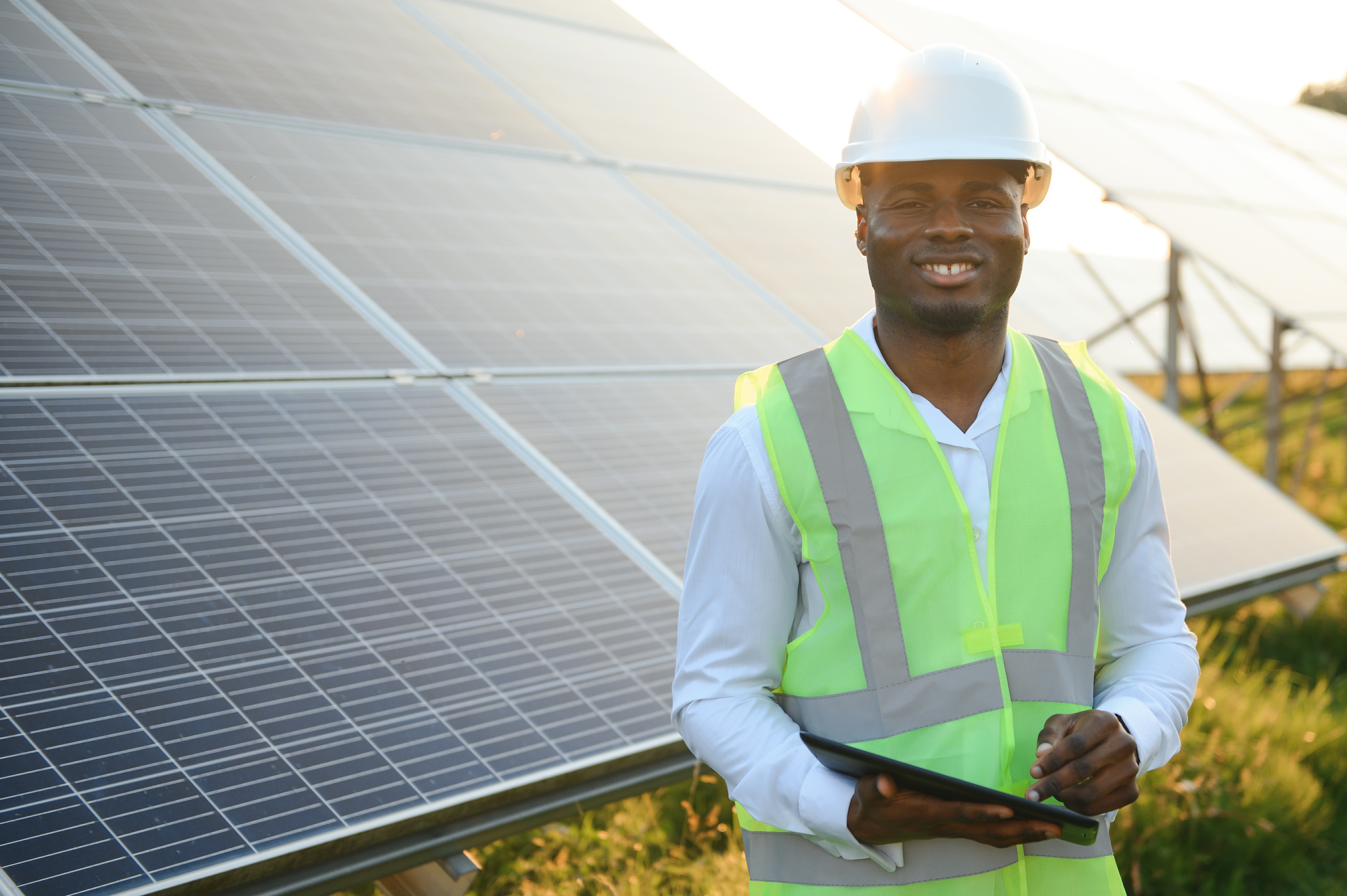 Black male engineer standing in front of solar panels