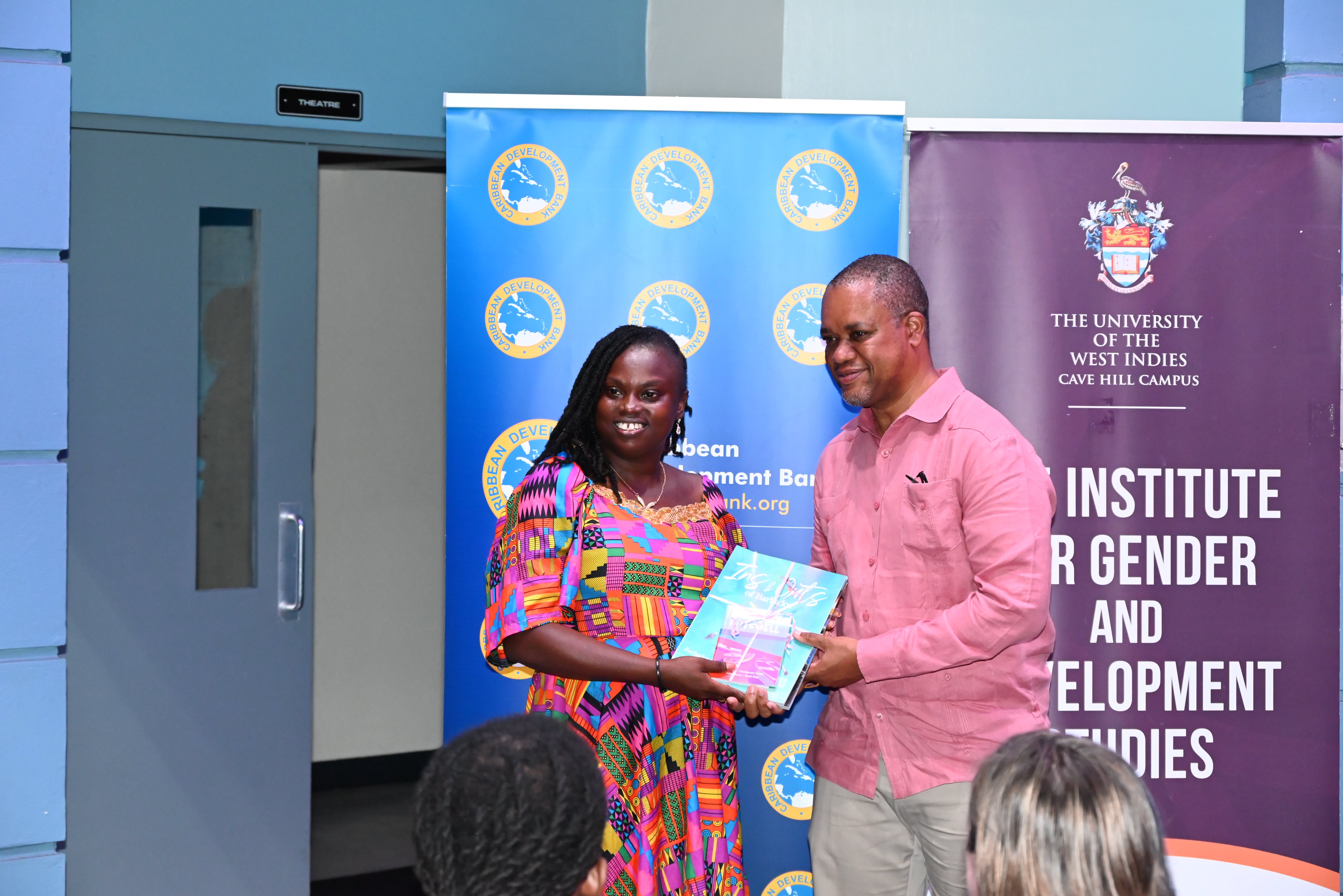 A black man presents a black woman with an award