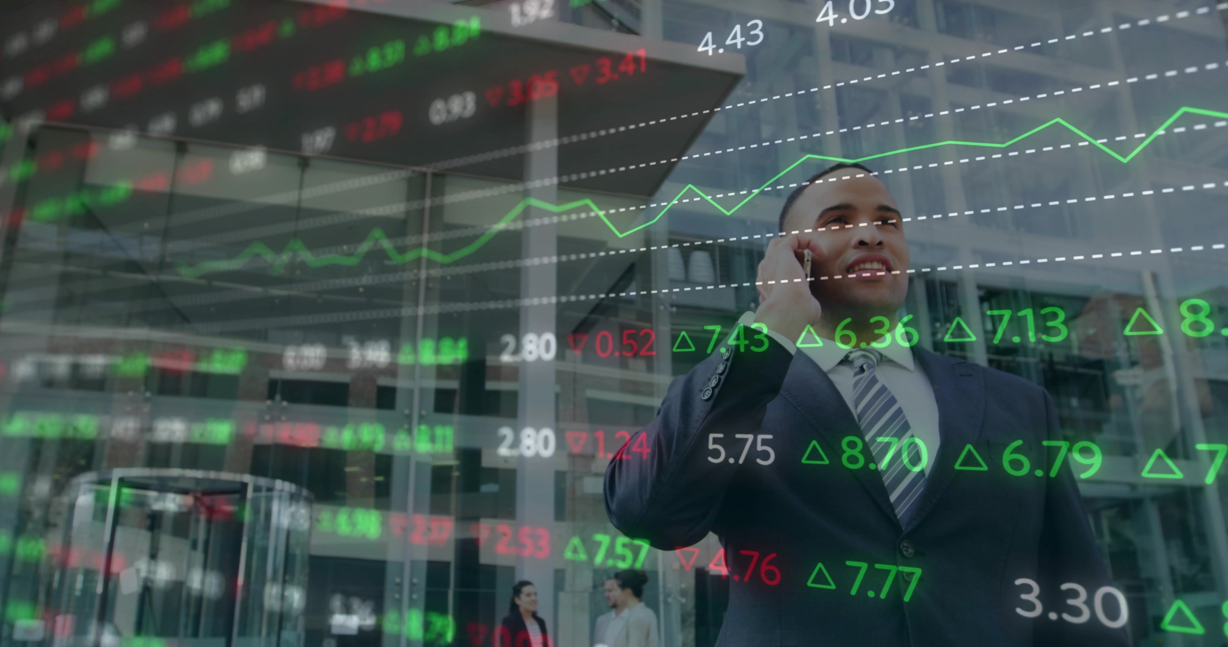Young businessman in suit looking up with stock exchange numbers superimposed over image