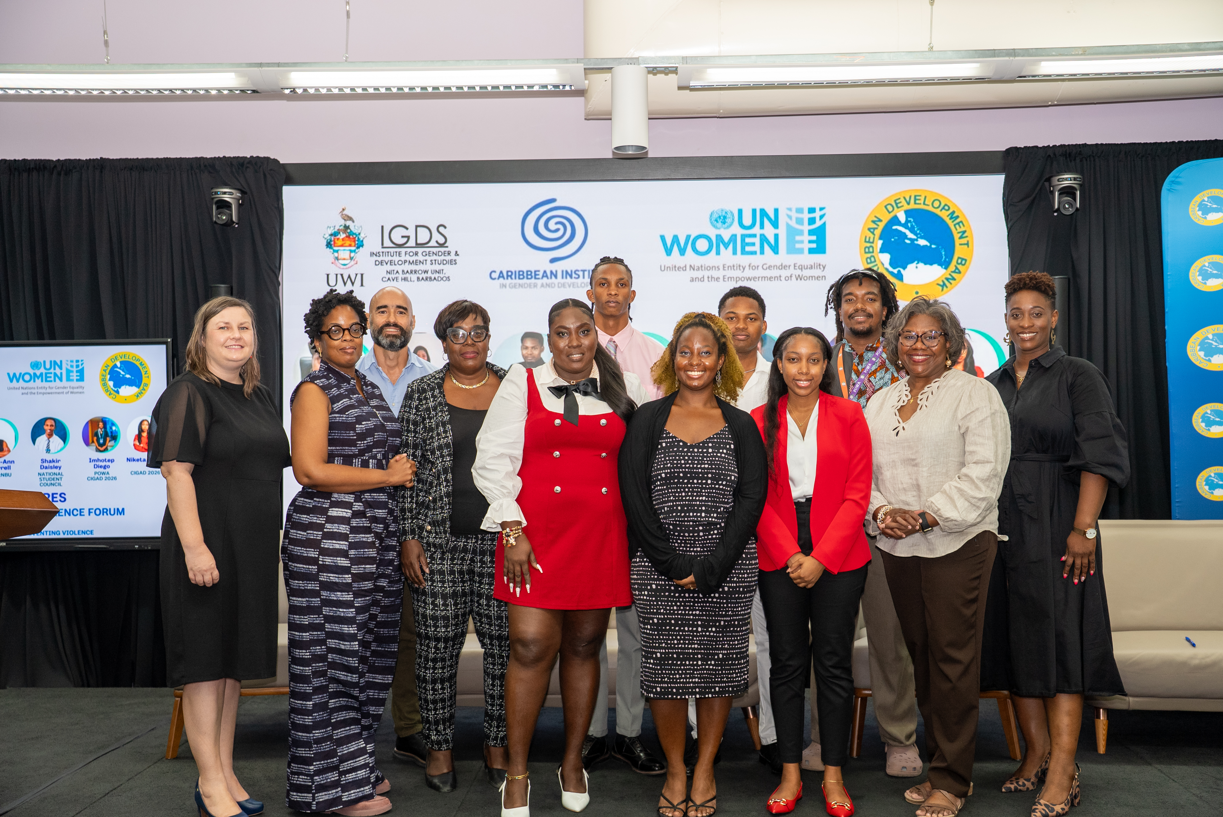 Group of people stand on stage at anti-violence forum in the Caribbean