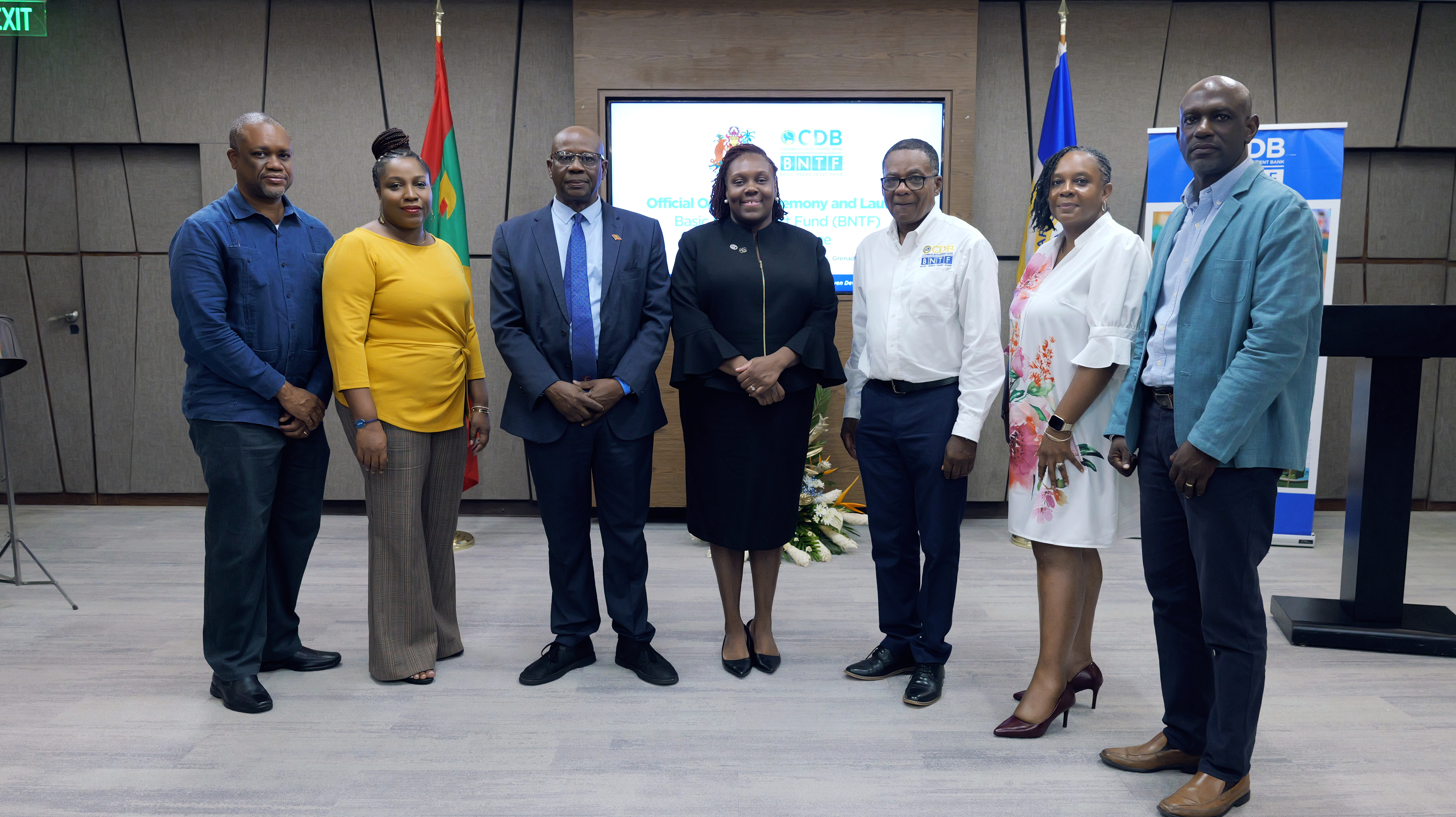 Three women and four men appear at the front of a meeting room for the launch of a new Caribbean Development Bank project in Grenada