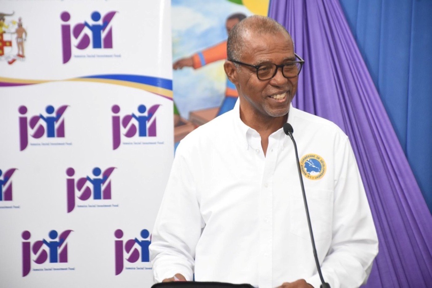 Male CDB official speaks at opening of upgraded classroom for students with special needs. 