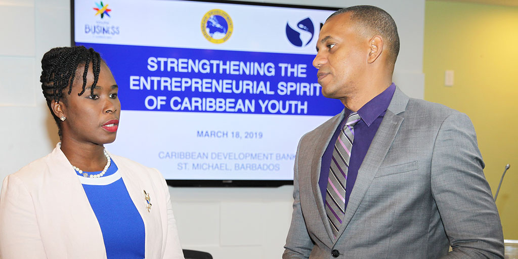 CDB Director of Project Daniel Best (at right in grey suit), in conversation with Executive Director of the Barbados Youth Business Trust Cardell Fergusson (in blue dress with of white jacket)