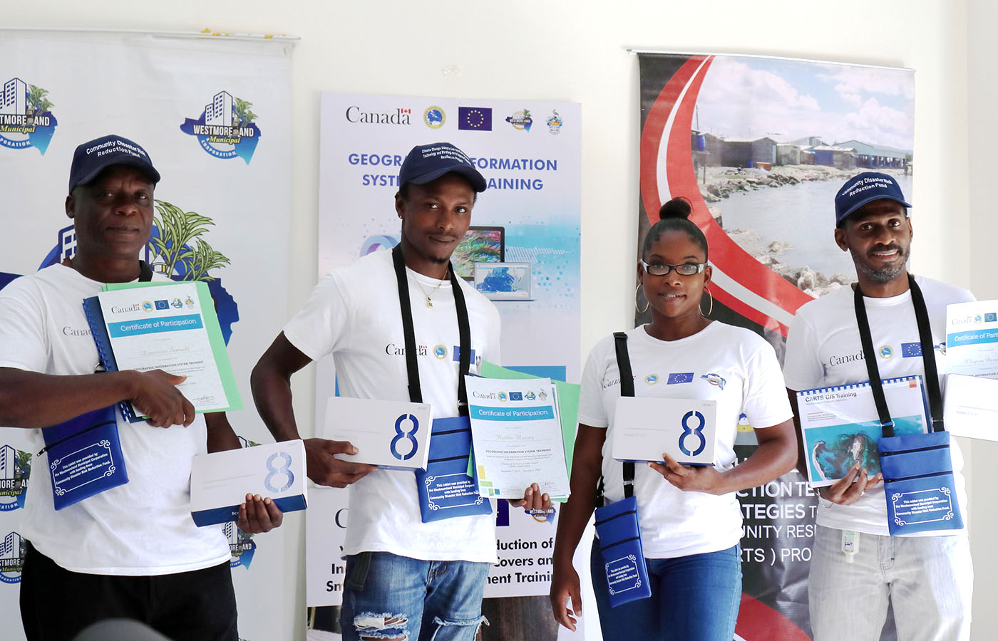 three males and one female standing holding certificates with branded banners in background