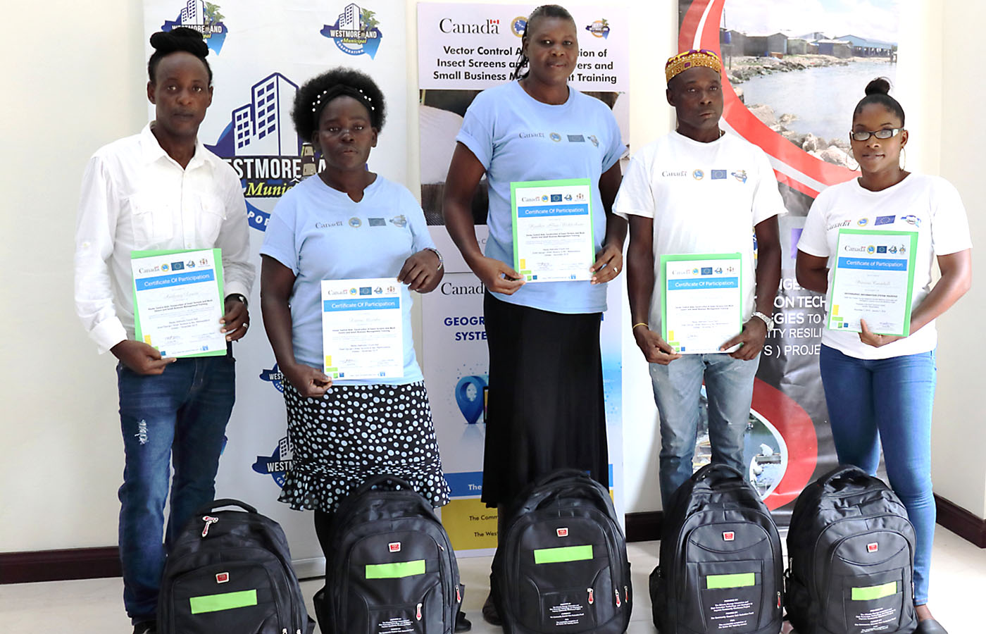 five persons standing with certificates with branded banners in the background