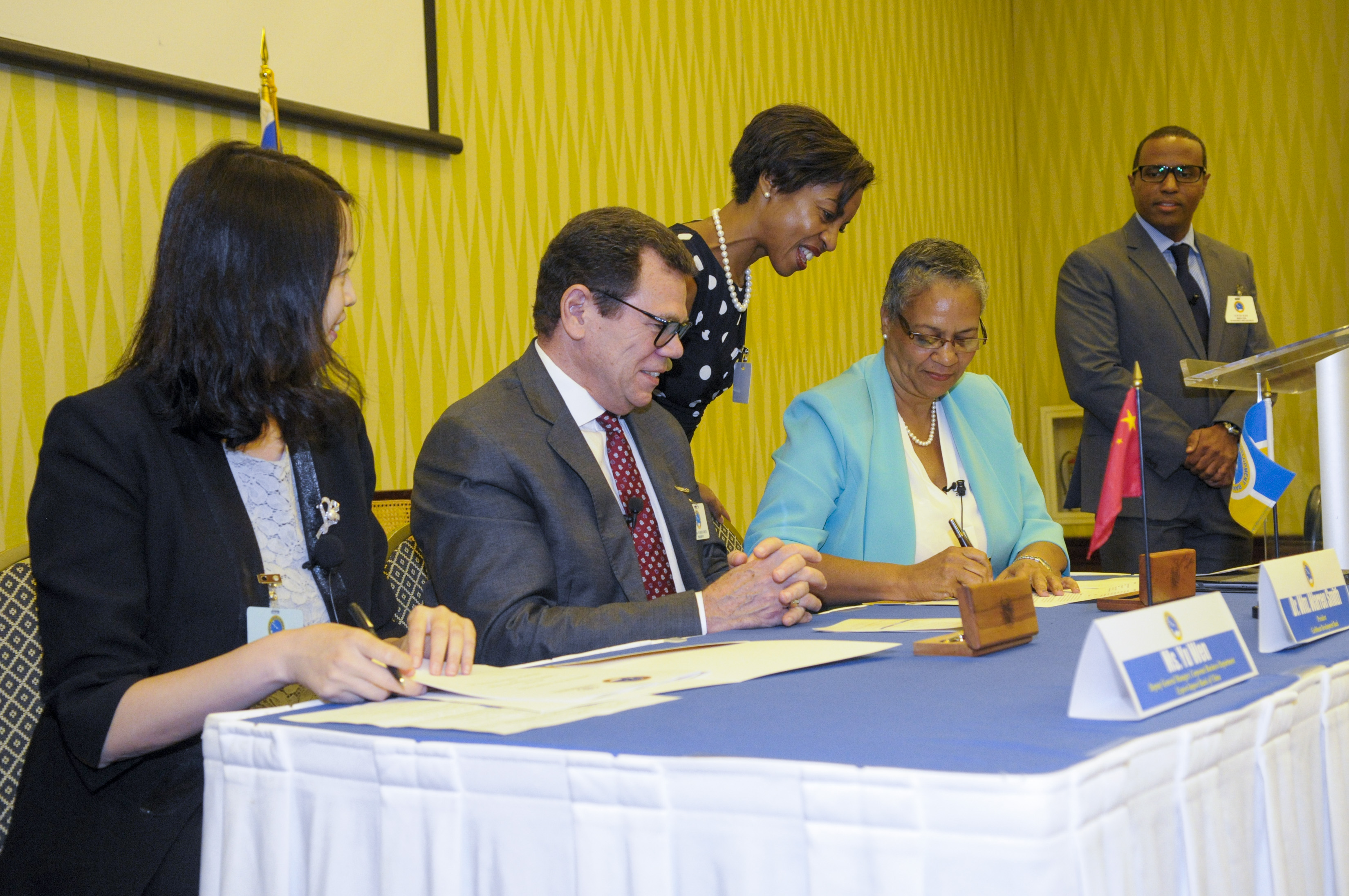 Monica La Bennett, Vice-President (Operations), CDB, signs the MOU between CDB and EXIM Bank of China on July 10, 2017. Looking on are (L-R) Yu Wen, Deputy General Manager, Corporate Business Department, EXIM Bank of China. Dr. Warren Smith, President, CDB, Diana Wilson Patrick, General Counsel, CDB and Dr. Justin Ram, Director, Economics, CDB.