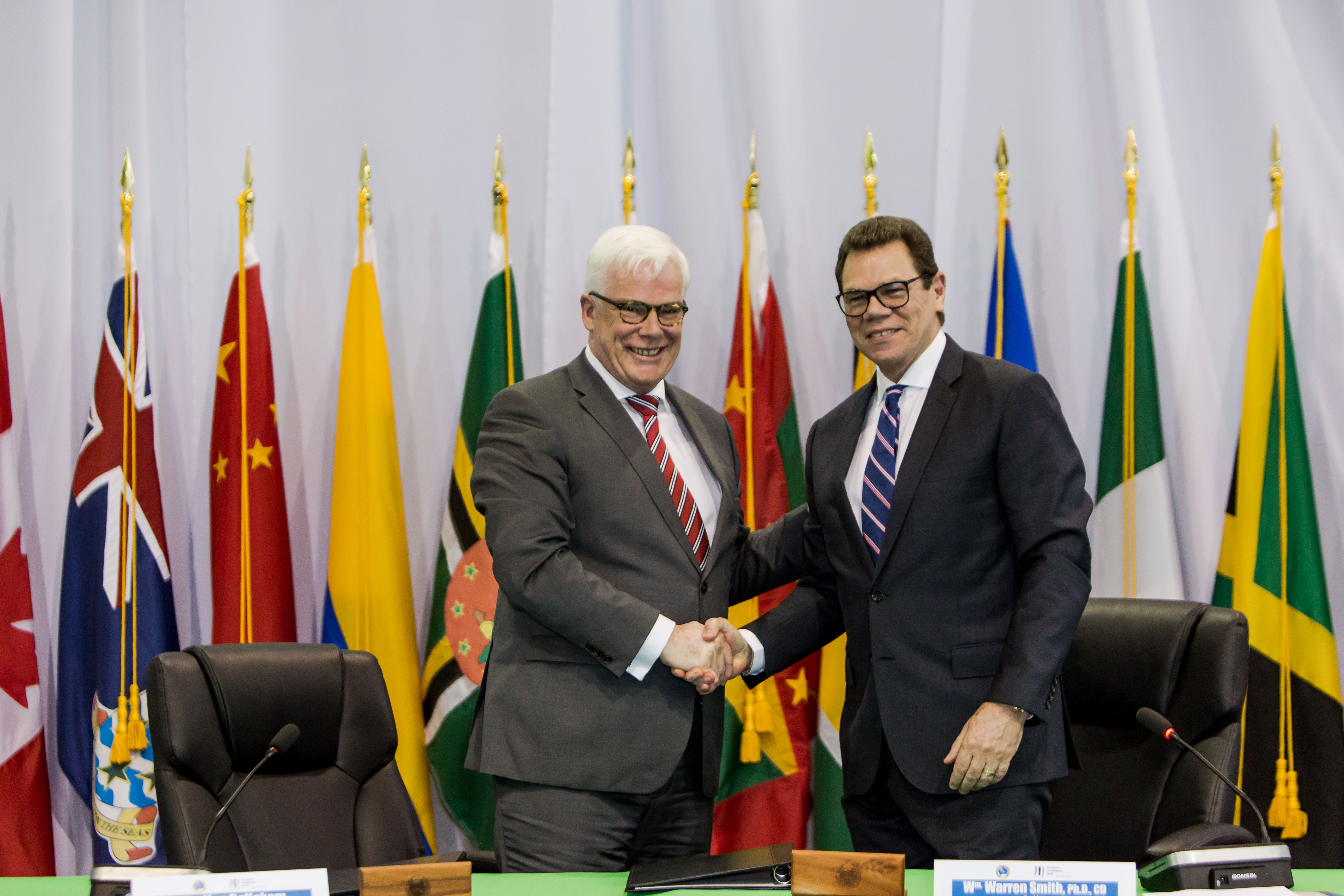 EIB Vice President, Pim Van Ballekom (left) and CDB President, Dr. Wm. Warren Smith (right) shake hands after signing the agreement for the Climate Action Framework Loan II on May 24, 2017 in Providenciales, Turks and Caicos Islands.