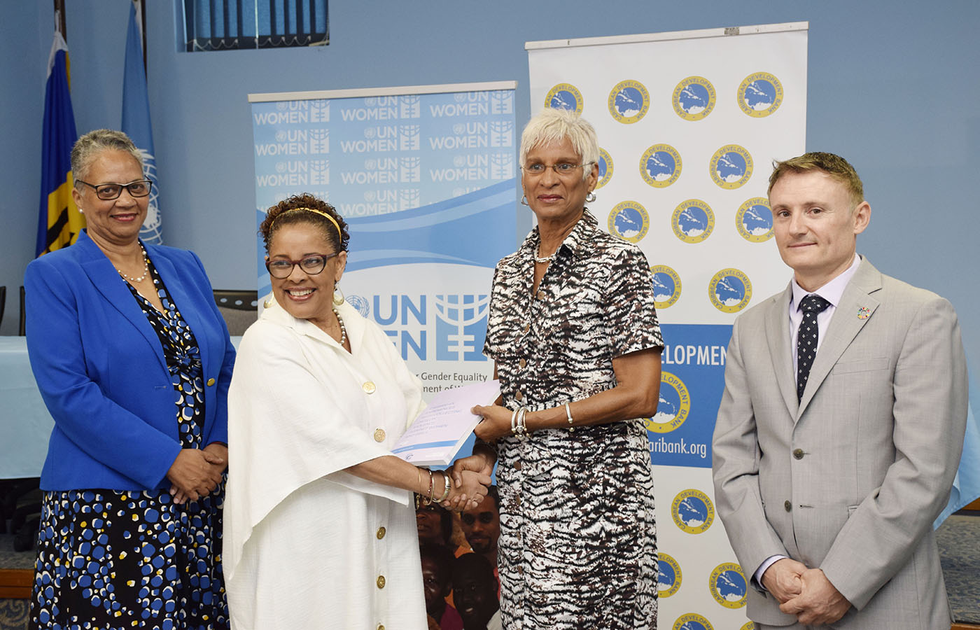 group photo of three females and one male standing in front of CDB and UN Women branded backdrops