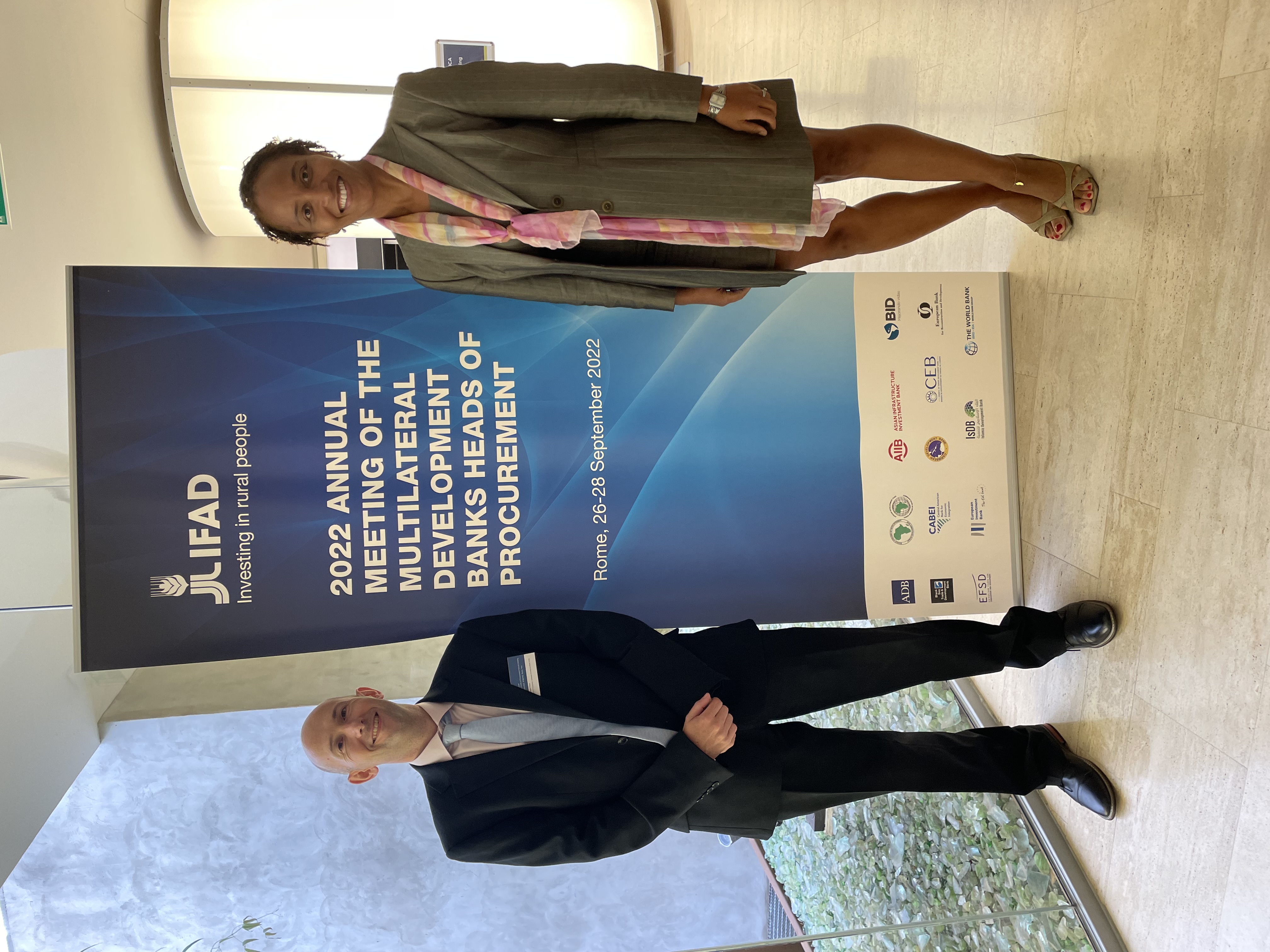 photo of male and female standing infront of banner