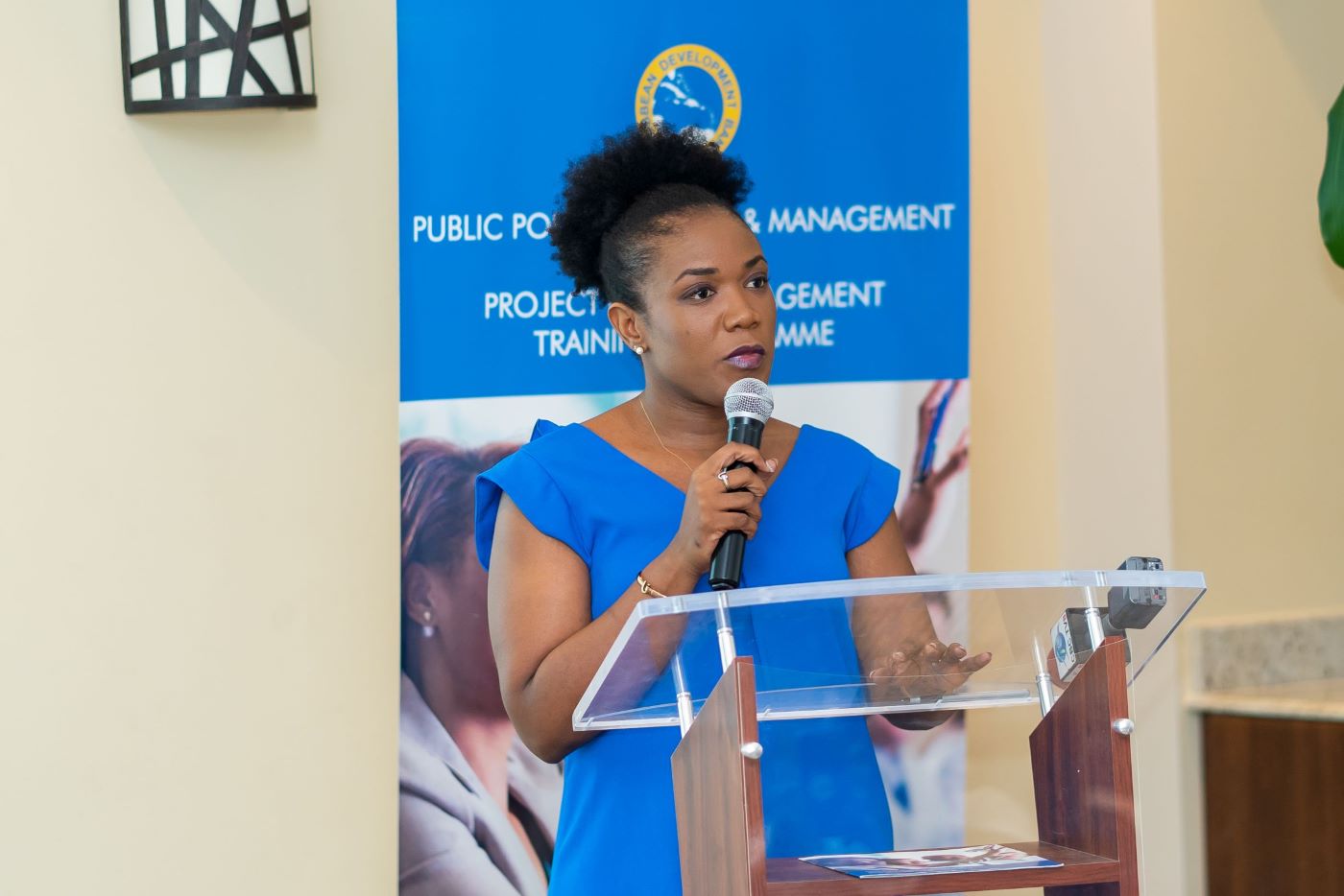 Barbados Minister of Economic Affairs Marsha Caddle standing at lectern in blue dress