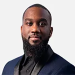 young black male in dark blue suit with black lapels and black shirt