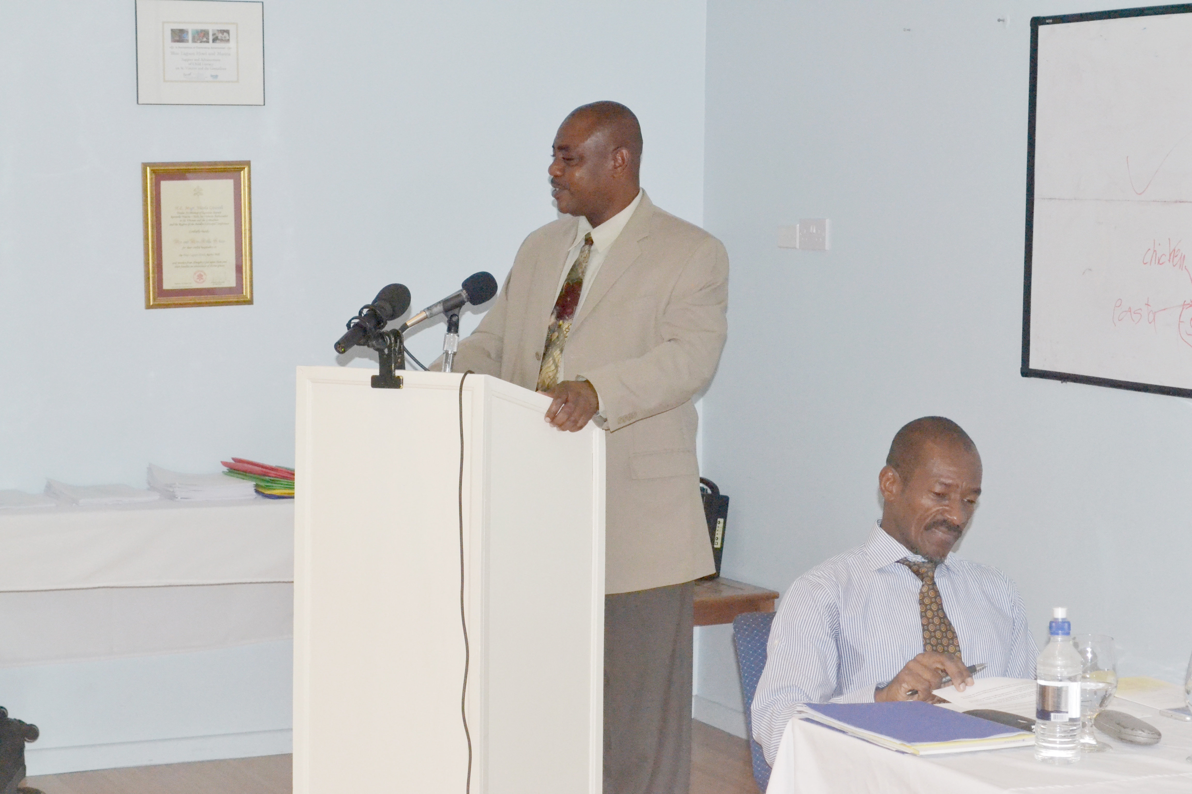 The Hon. Frederick Stephenson, Minister of National Mobilisation, Social Development, Gender and Youth Affairs, standing at podium, believes scientifically assessing community willingness to engage is key to developing successful climate resilience programmes.