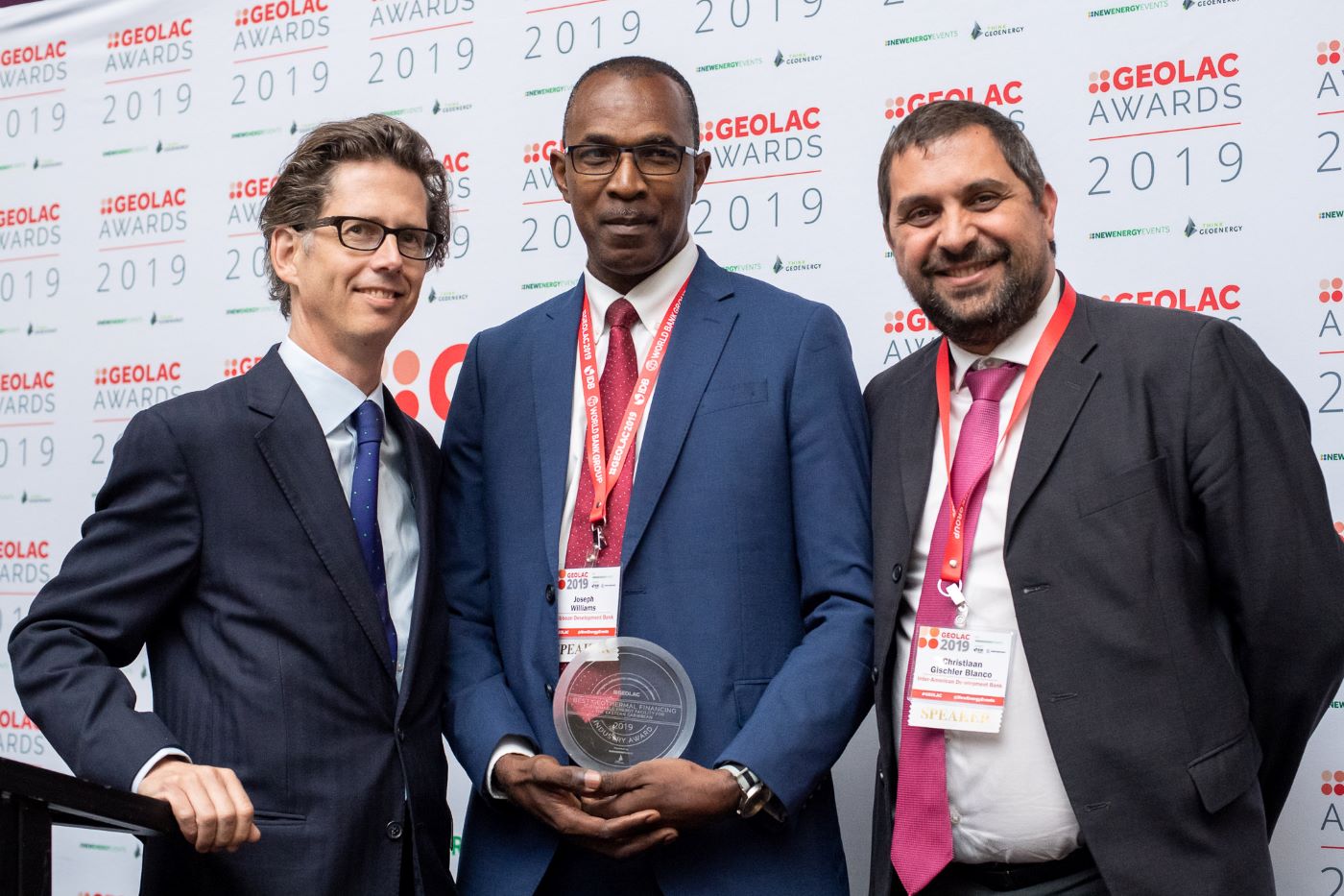 CDB's Joseph Williams and two others standing against backdrop at prize ceremony.