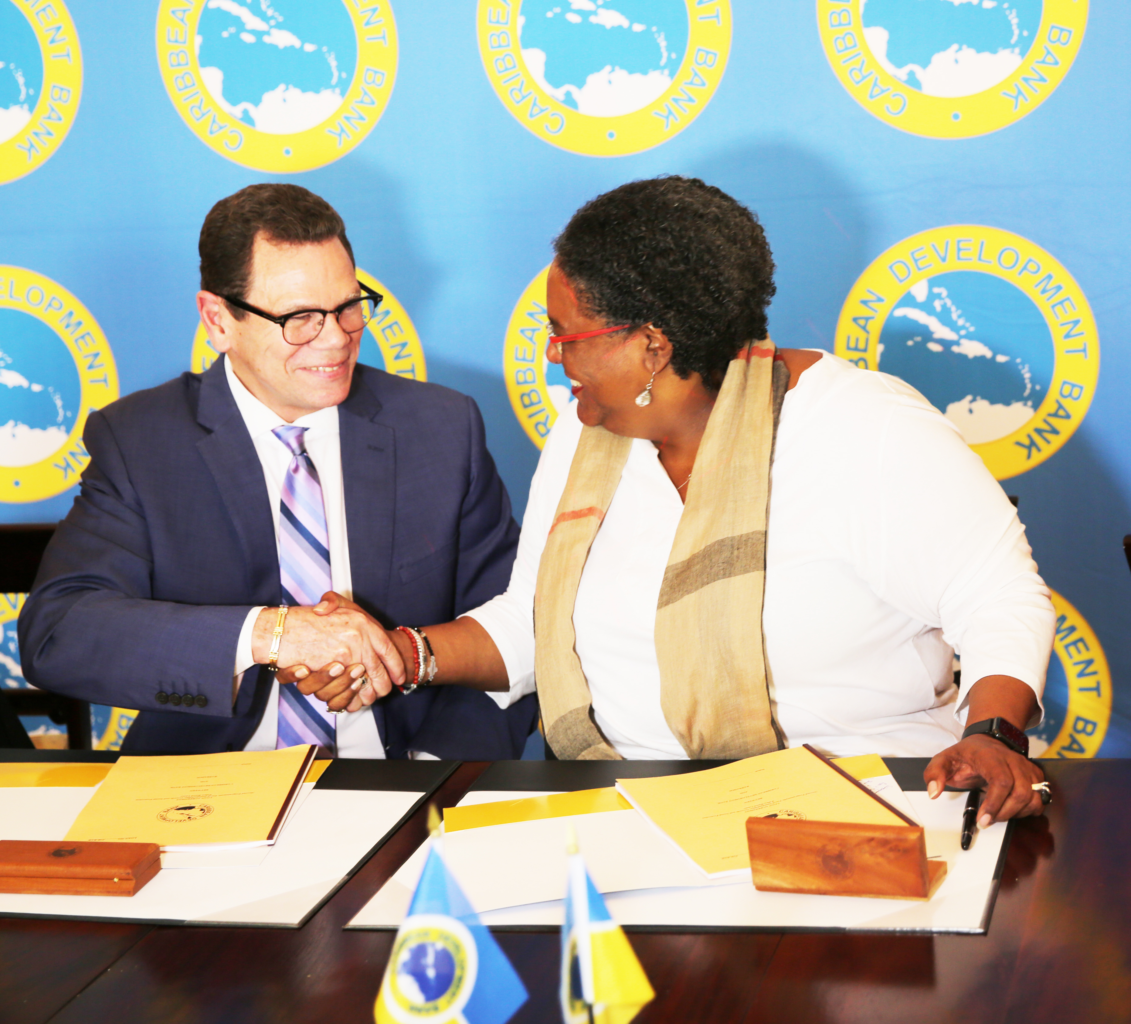 CDB President Smith (l.) and Prime Minister of Barbados Mottley shaking hands after signing the loan