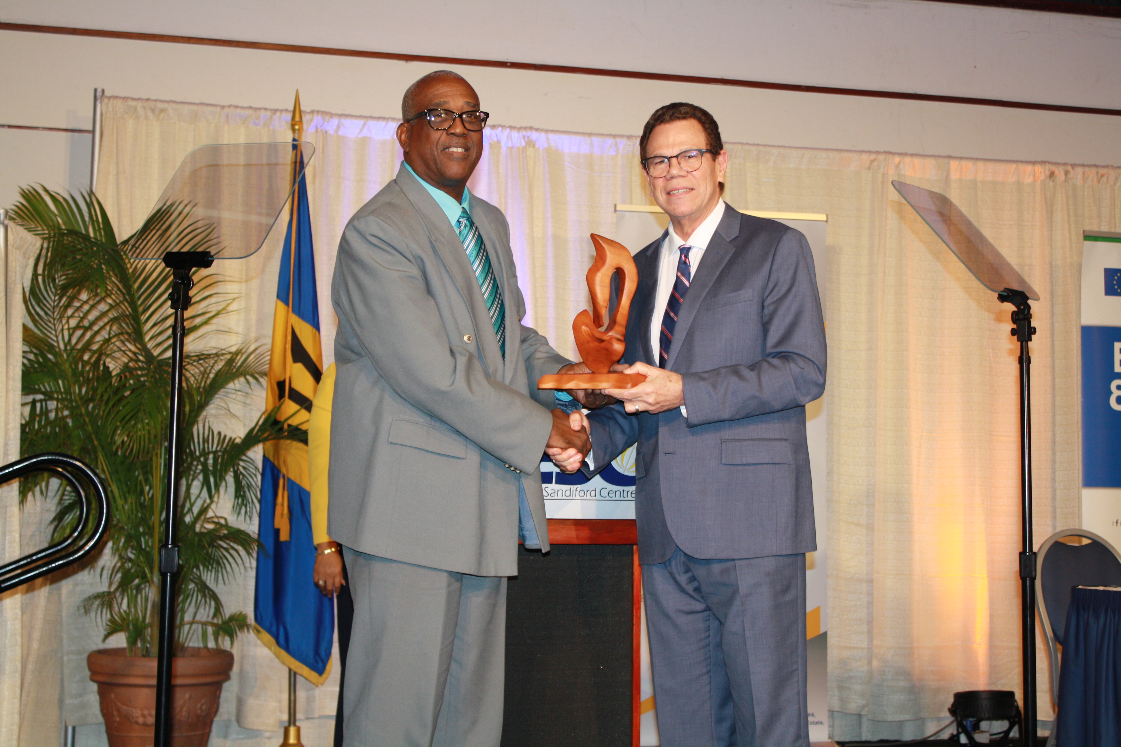 CDB president Dr Warren Smith accepting a token of appreciation from Barbados Small Business Association president Wayne Willock