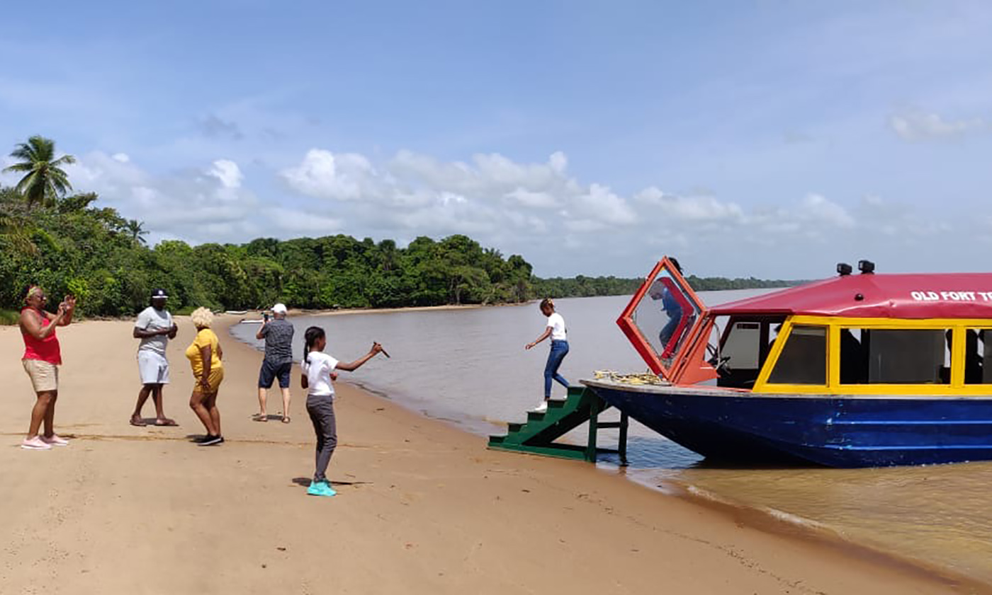 People disembarking onto a beach from a boat tour