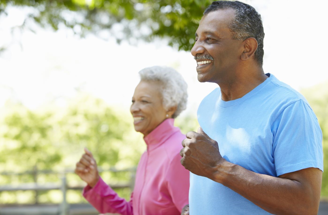 Smiling older couple jogging