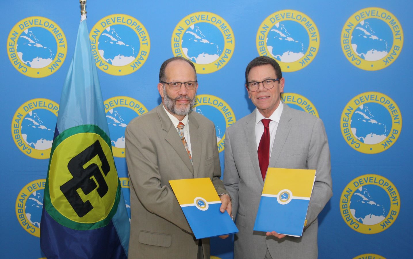 CARICOM SEcretary General Irwin LaRocque and CDB President Dr Warren Smith shaking hands.