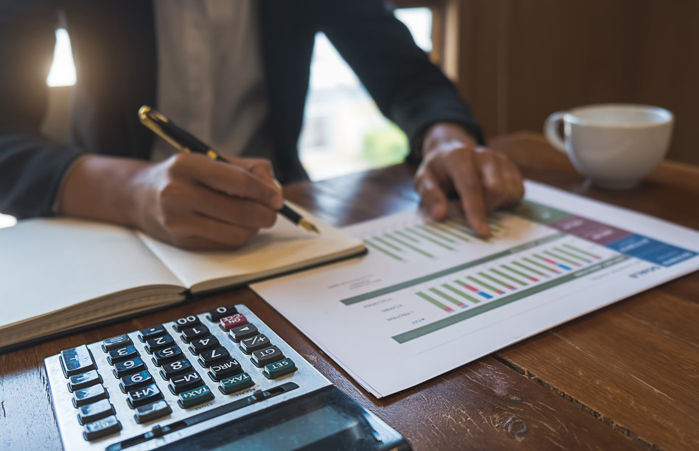 man in suit with calculator and spreadsheets